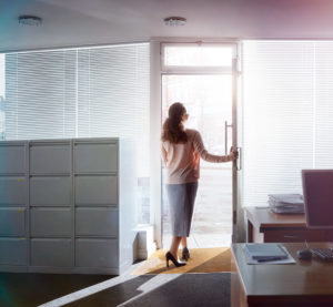 Image of a woman opening the door of an office