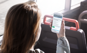 Image of a woman looking at Universal Credit information on her mobile phone whilst on a bus